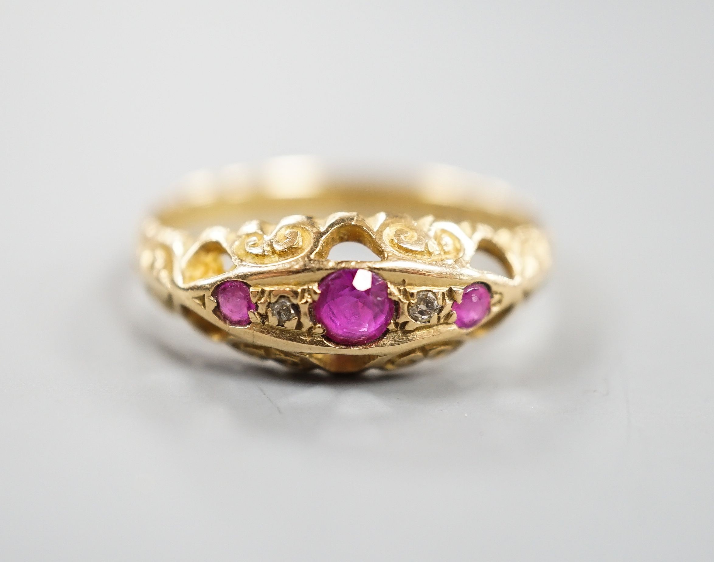 A George V 18ct gold three stone ruby and two stone diamond chip set ring, size Q, gross weight 3 grams.